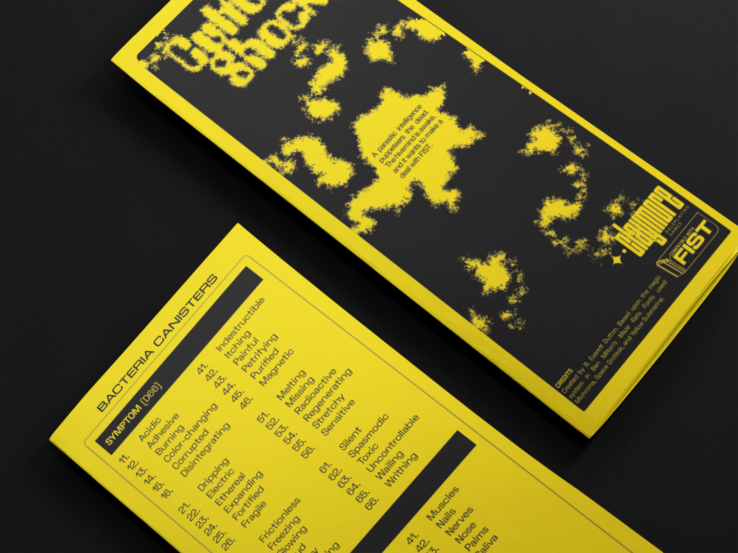 A mockup of the bright yellow and black CULTURE SHOCK pamphlet. Two copies are on a black table, showing the psychedelic cover art and the back.