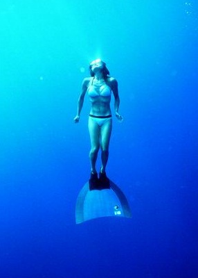 Woman free diving with monofin