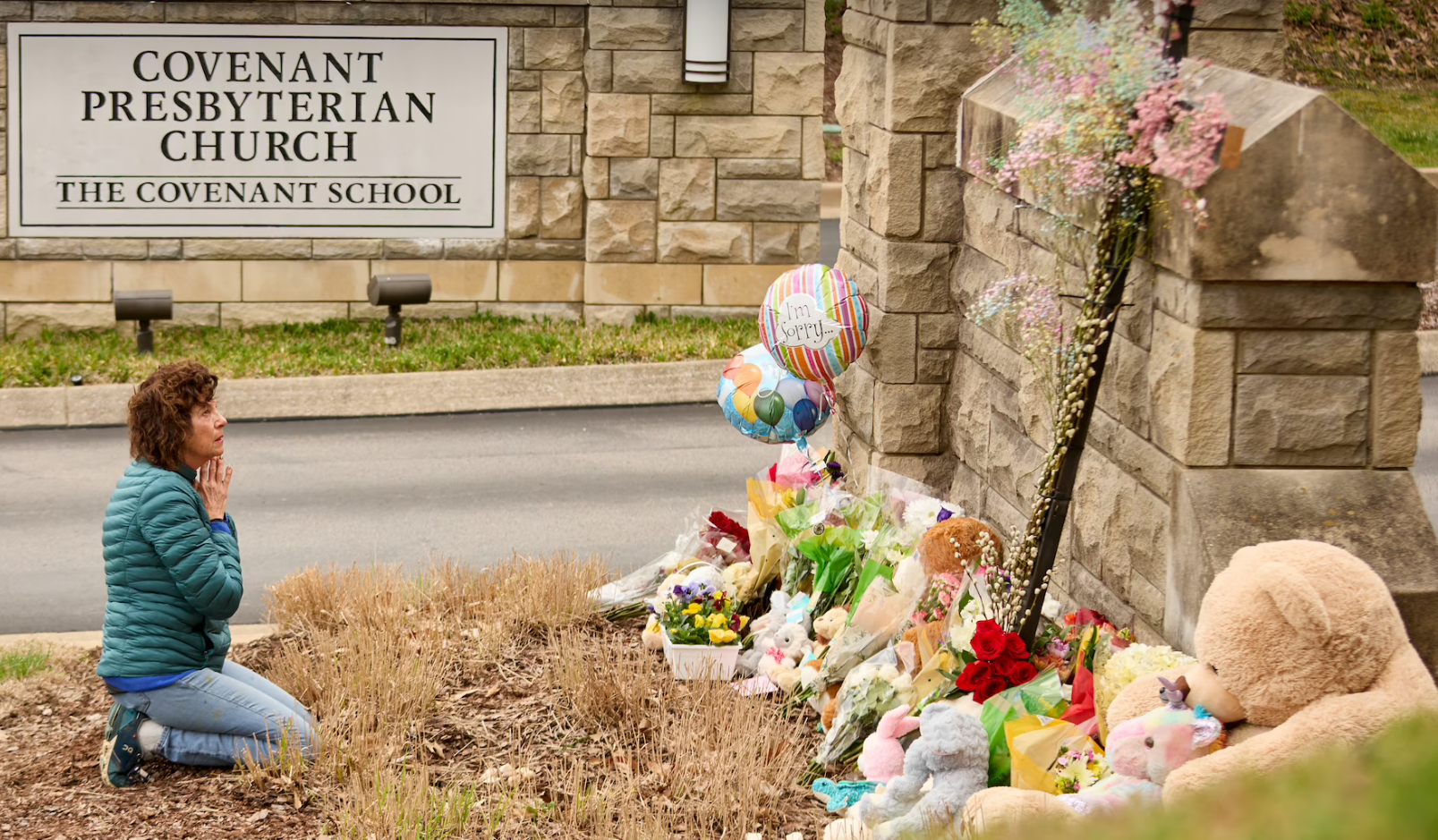 Woman kneeling and praying at the makeshift shrine for the victims of the Covenant School shooting, Nashville TN