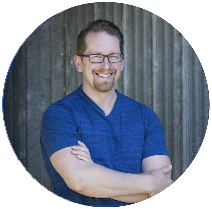 Aric holds his arms and grins