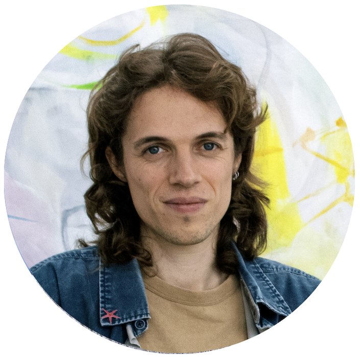 Ivan is smiling, in the background is his artwork