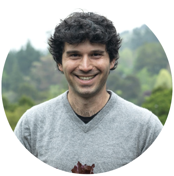 Yotam grins warmly, in the background are trees and bright skies