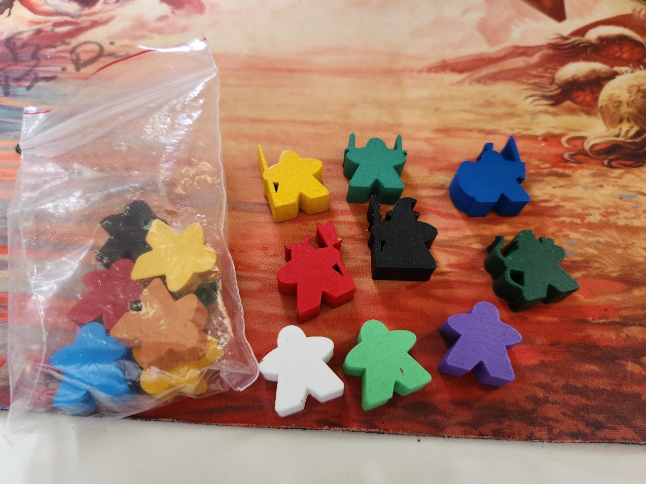 a plastic bag and multiple meeples, each with a different color, six of which have different forms: a wizard, a barbarian, a duel-wielder, a lancer, a bowman, and a swordsman with a shield