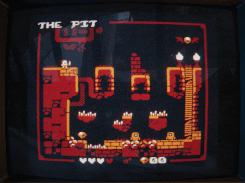 Retro platformer game screen with a character, platforms, spikes, gems, and the level title 'THE PIT' at the top.